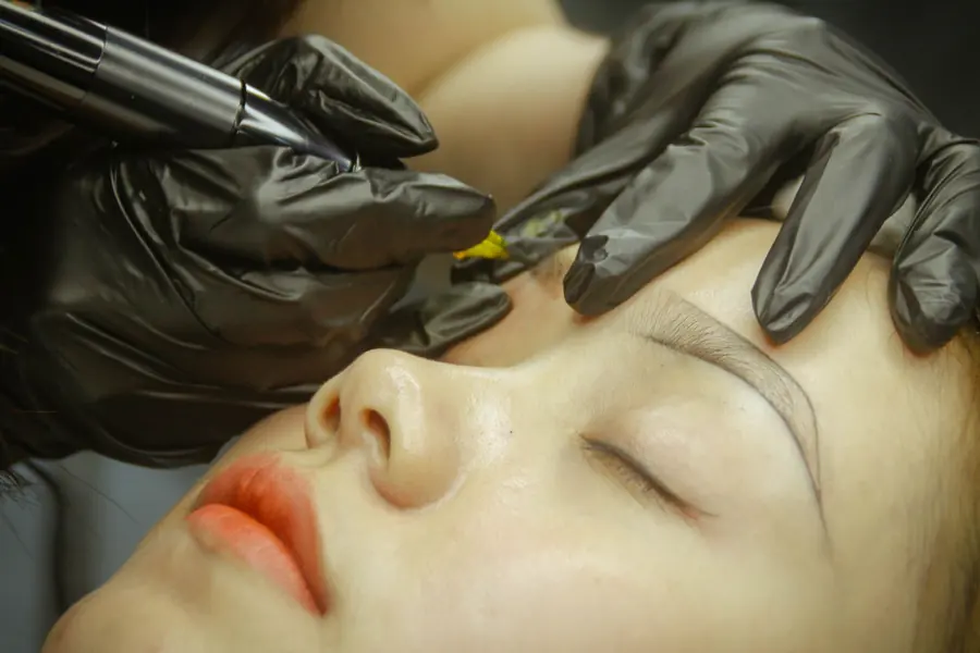 Mistrová aplikuje permanentní make-up obočí v černých rukavicích